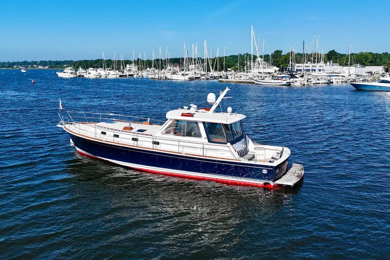 Slide: The Image of 2001 Grand Banks 49 Eastbay HX yacht on calm water near marina. - 3