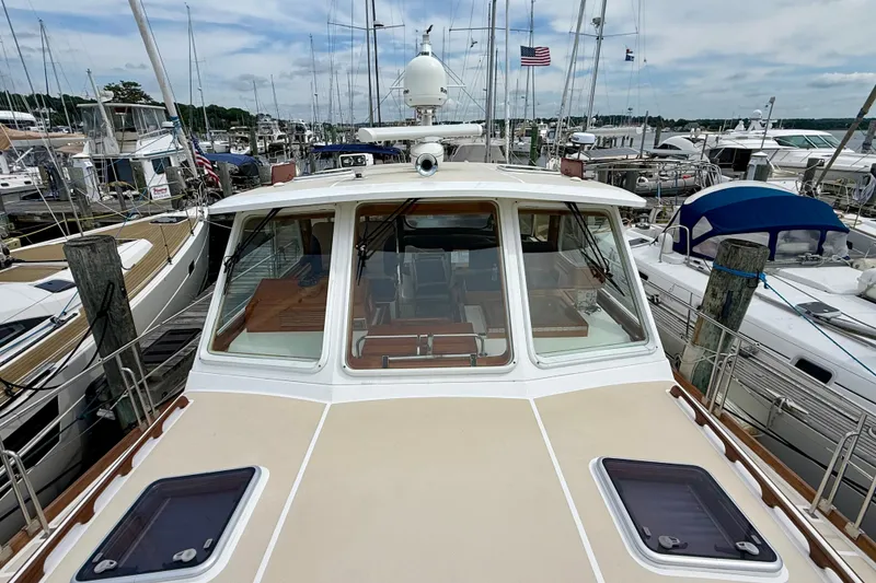 Slide: The Image of 2001 Grand Banks 49 Eastbay HX yacht docked at a marina, surrounded by other boats. - 25