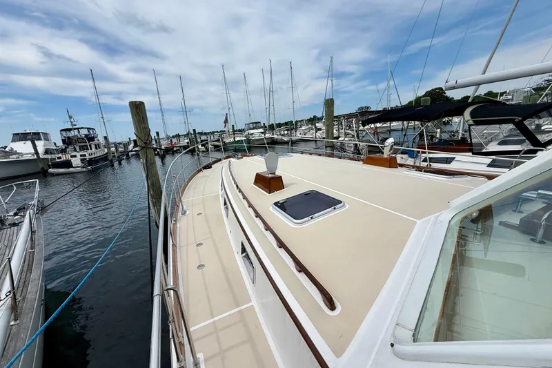 Slide: The Image of 2001 Grand Banks 49 Eastbay HX yacht docked at a marina, surrounded by sailboats. - 20