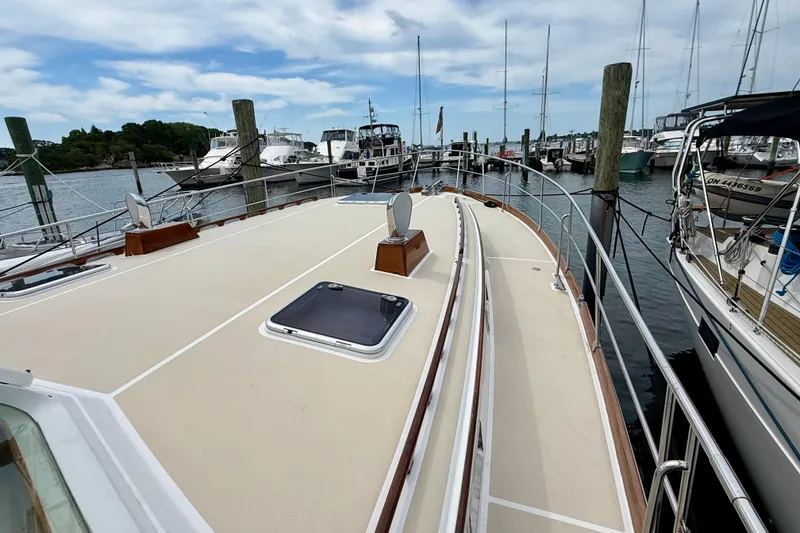 Slide: The Image of 2001 Grand Banks 49 Eastbay HX yacht docked at a marina, showcasing spacious deck and sleek design. - 21