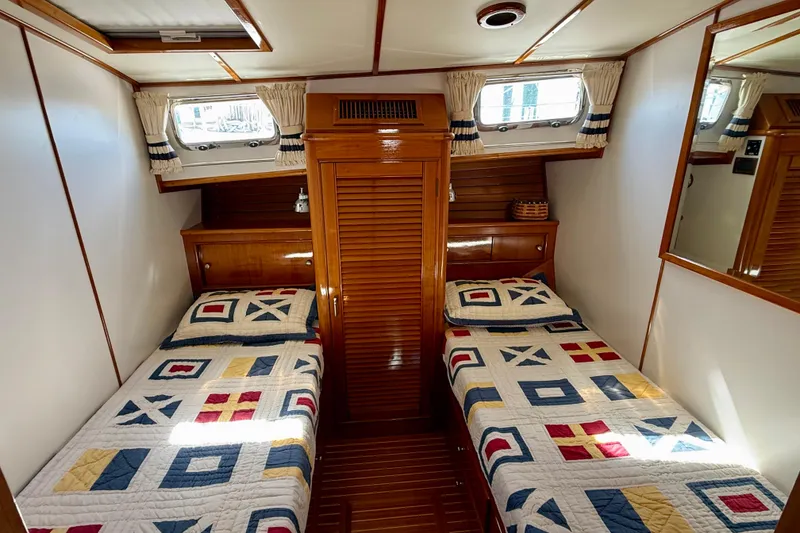 Slide: The Image of Cabin interior of 2001 Grand Banks 49 Eastbay HX with twin beds and nautical-themed quilts. - 43