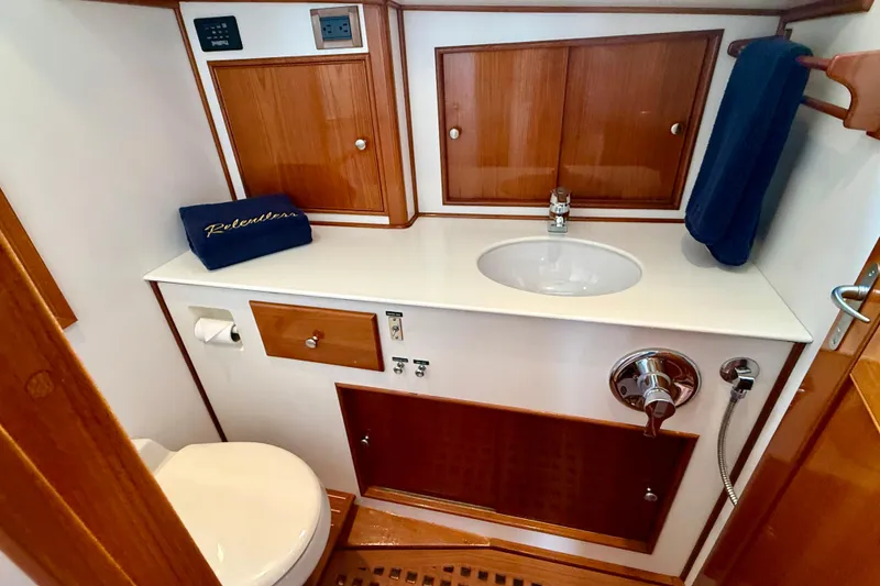 Slide: The Image of Luxurious 2001 Grand Banks 49 Eastbay HX yacht bathroom with wooden cabinetry and modern fixtures. - 48