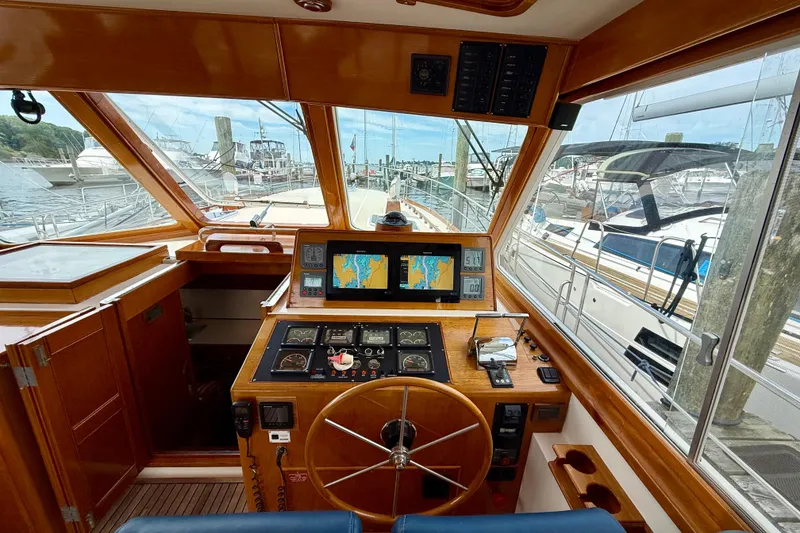 Slide: The Image of Helm of 2001 Grand Banks 49 Eastbay HX yacht with navigation screens and wooden steering wheel. - 60