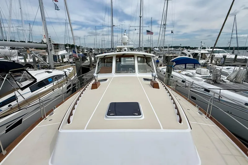 Slide: The Image of 2001 Grand Banks 49 Eastbay HX yacht docked at a marina, surrounded by sailboats. - 22
