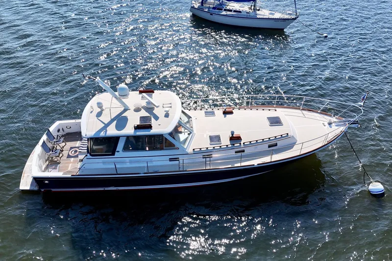 Slide: The Image of 2001 Grand Banks 49 Eastbay HX yacht on shimmering water, aerial view. - 9