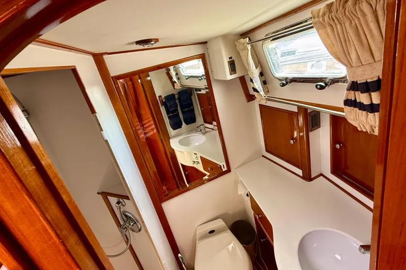Slide: The Image of Luxurious bathroom interior of 2001 Grand Banks 49 Eastbay HX yacht, featuring wood accents and modern fixtures. - 40