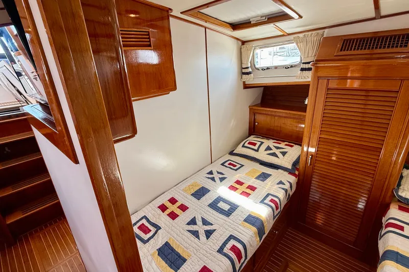 Slide: The Image of 2001 Grand Banks 49 Eastbay HX cabin with twin beds and nautical-themed quilts. - 45