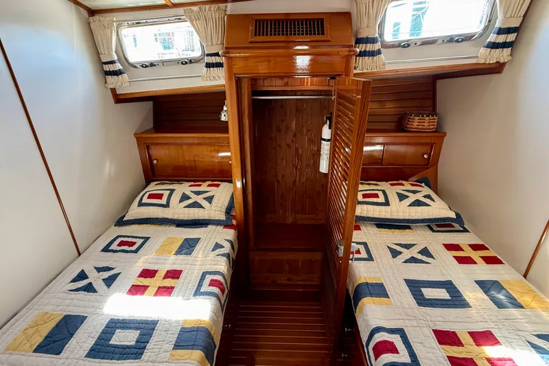 Slide: The Image of Cabin interior of 2001 Grand Banks 49 Eastbay HX with twin beds and nautical-themed quilts. - 46