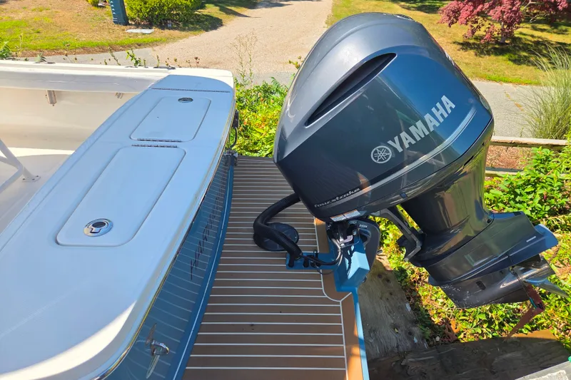 Slide: The Image of 2020 Regulator 23 Forward Seating boat with Yamaha outboard motor, docked outdoors. - 13