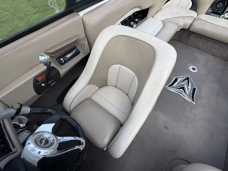 Slide: The Image of Interior of a 2007 Malibu Wakesetter 23 LSV with beige upholstery and steering wheel. - 14