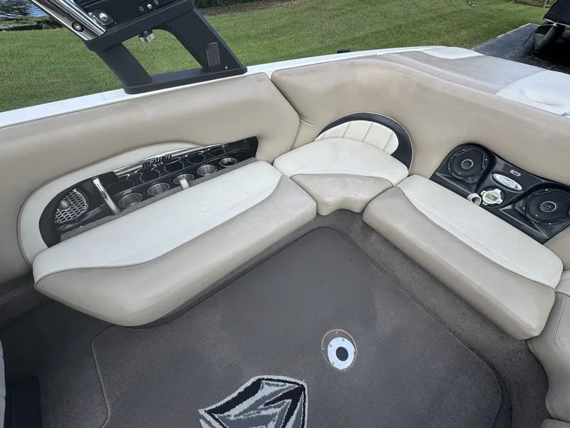 Slide: The Image of Interior of a 2007 Malibu Wakesetter 23 LSV with beige upholstery and cup holders. - 6