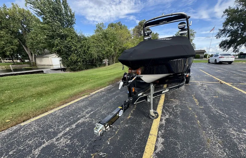 Slide: The Image of A 2007 Malibu Wakesetter 23 LSV on a trailer in a parking lot, with trees in the background. - 31
