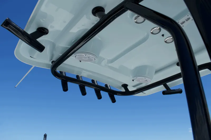 Slide: The Image of 2024 Sea Hunt BX22BR boat T-top with rod holders against blue sky. - 14