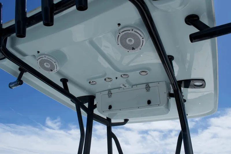 Slide: The Image of 2024 Sea Hunt BX22BR boat T-top with speakers and rod holders against blue sky. - 13