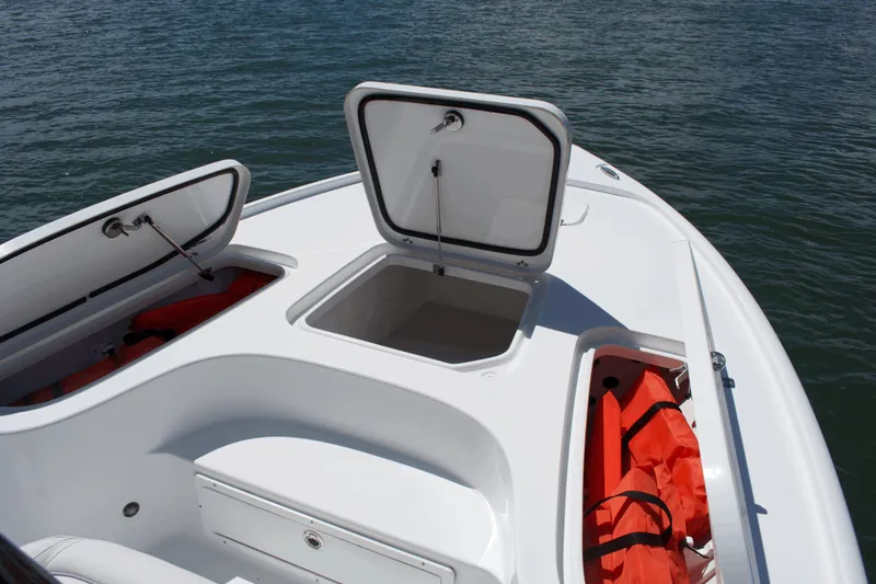 Slide: The Image of 2024 Sea Hunt BX22BR boat with open storage compartments on calm water. - 7