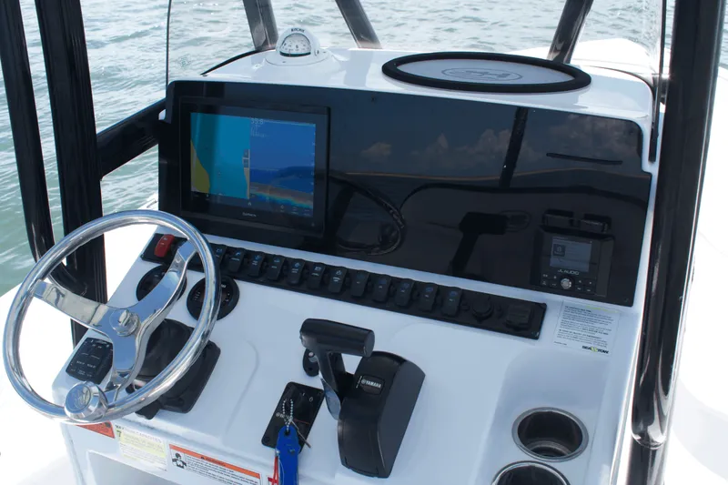 Slide: The Image of 2024 Sea Hunt BX22BR boat dashboard with steering wheel and navigation display. - 11