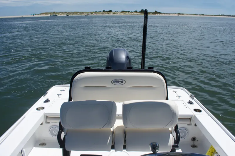 Slide: The Image of 2024 Sea Hunt BX22BR boat on open water, featuring comfortable seating and scenic shoreline view. - 16