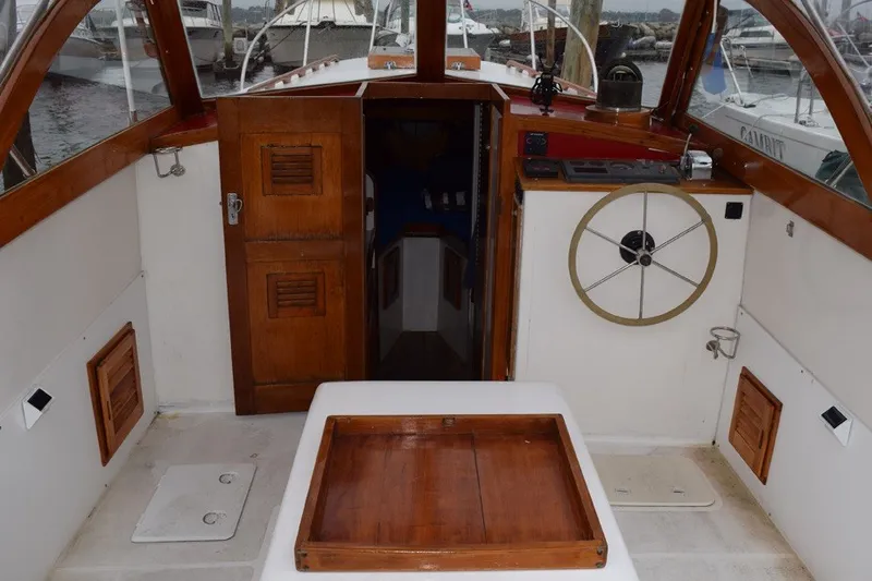 Slide: The Image of 1974 Wasque 32 boat interior with wooden accents and steering wheel. - 11