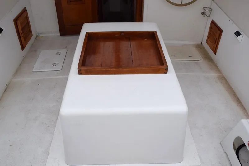 Slide: The Image of Interior of a 1974 Wasque 32 boat featuring a wooden table on a white base. - 12