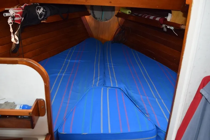 Slide: The Image of Cozy cabin interior of a 1974 Wasque 32 boat with blue-striped bedding. - 28