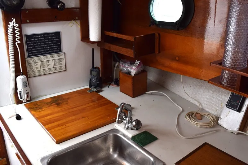 Slide: The Image of 1974 Wasque 32 boat interior with sink, cutting board, and communication equipment. - 22