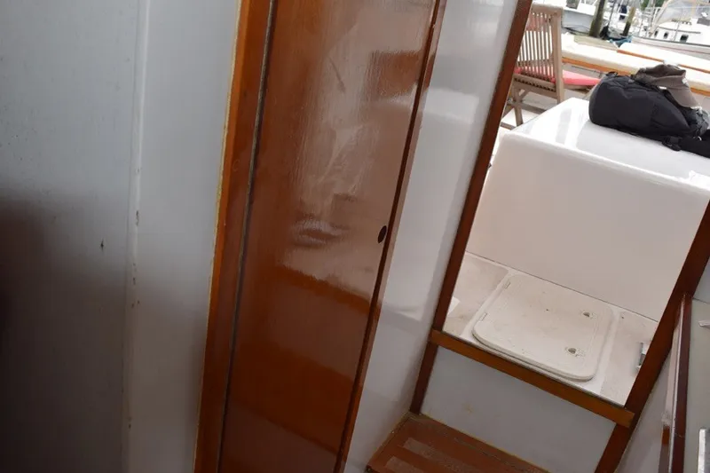 Slide: The Image of Interior view of a 1974 Wasque 32 boat with wooden door and seating area. - 26
