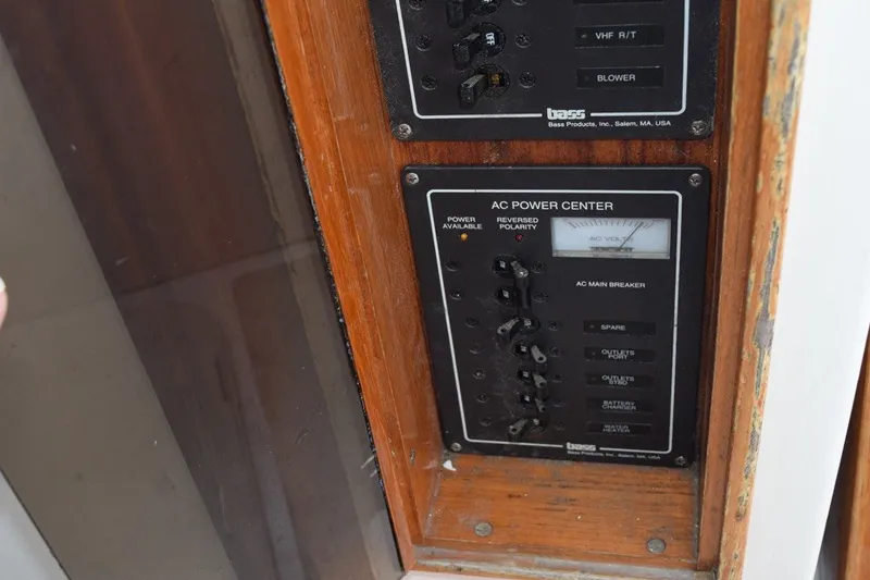 Slide: The Image of 1974 Wasque 32 AC power center panel with switches and indicators. - 33