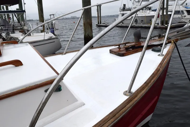 Slide: The Image of 1974 Wasque 32 boat docked at marina, featuring red hull and white deck. - 9
