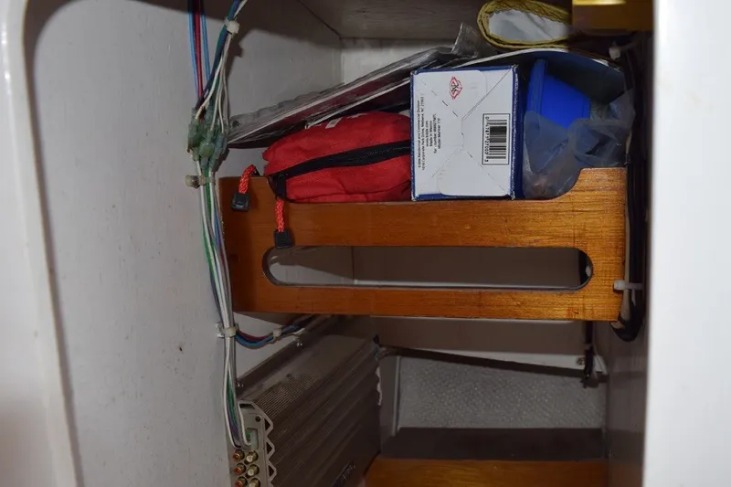 Slide: The Image of Storage compartment in a 1974 Wasque 32 boat with various items and wiring. - 31