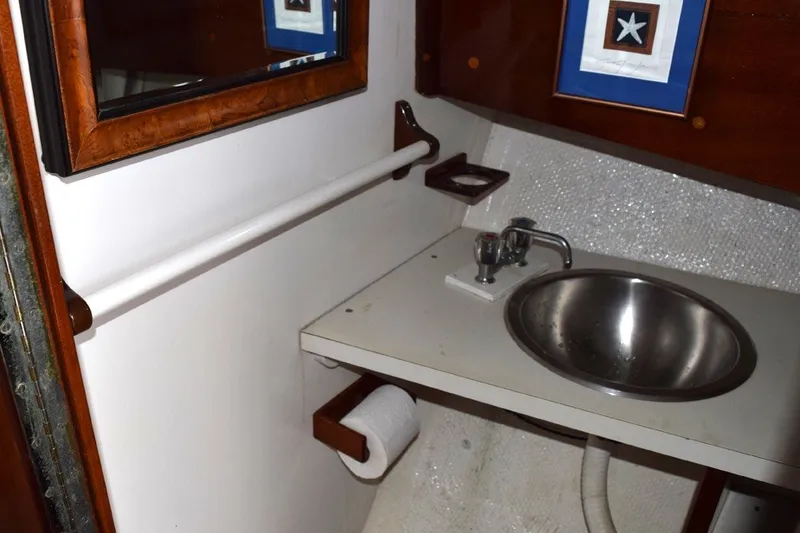 Slide: The Image of 1974 Wasque 32 boat bathroom with sink, mirror, and nautical decor. - 36