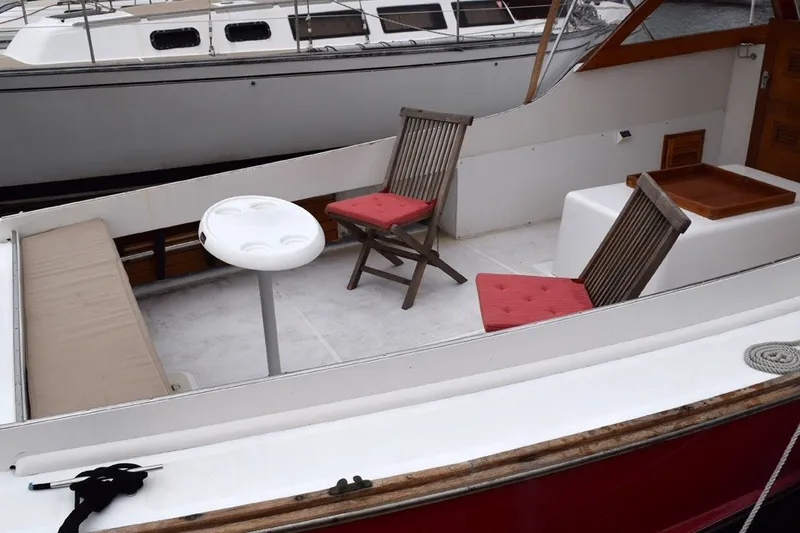 Slide: The Image of 1974 Wasque 32 boat interior with chairs and table, docked beside another vessel. - 6
