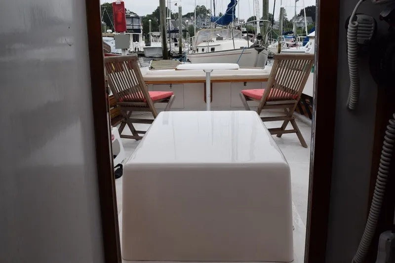Slide: The Image of 1974 Wasque 32 boat interior with wooden chairs and marina view. - 13