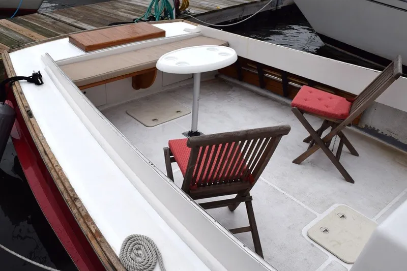 Slide: The Image of 1974 Wasque 32 boat interior with wooden chairs and table on deck. - 10
