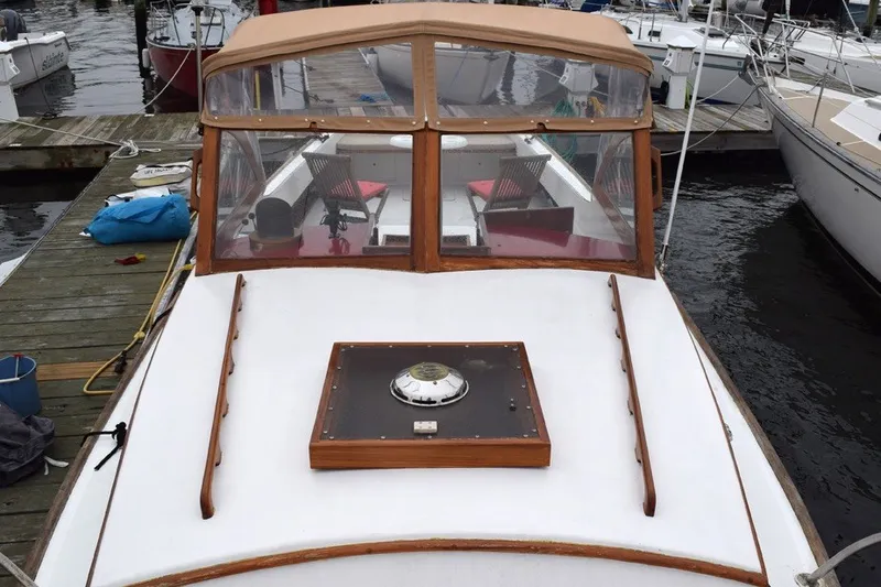 Slide: The Image of 1974 Wasque 32 boat docked, featuring a wooden cabin and white deck. - 8