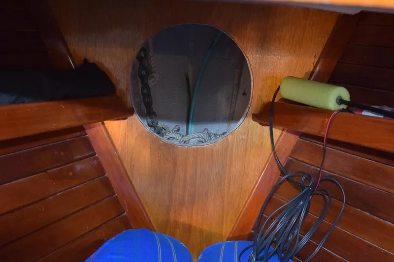 Slide: The Image of Interior of a 1974 Wasque 32 boat with wooden paneling and storage shelves. - 30
