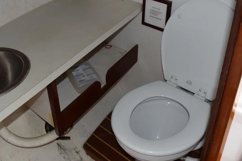 Slide: The Image of 1974 Wasque 32 boat bathroom with toilet, sink, and storage shelf. - 35