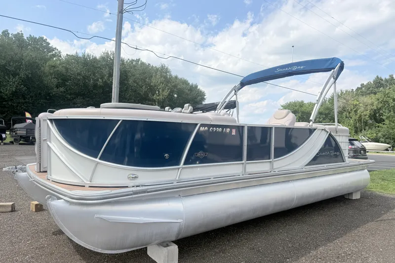 Slide: The Image of 2017 South Bay 500 pontoon boat with blue and white design, parked outdoors. - 1