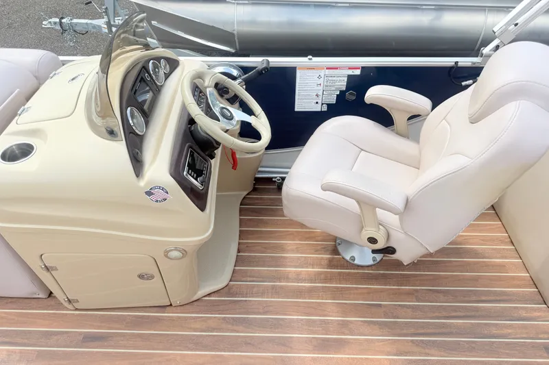 Slide: The Image of Captain's chair and helm of 2017 South Bay 500 boat, featuring beige upholstery and wood flooring. - 11