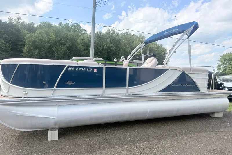 The Image of 2017 South Bay 500 pontoon boat with blue and white design, parked outdoors. - 0