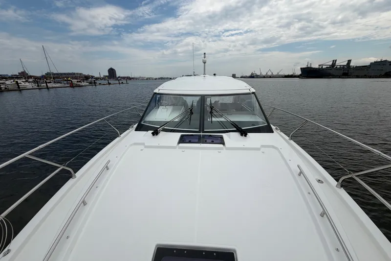 Slide: The Image of 2015 Jeanneau Leader 40 yacht docked at a marina under a partly cloudy sky. - 16