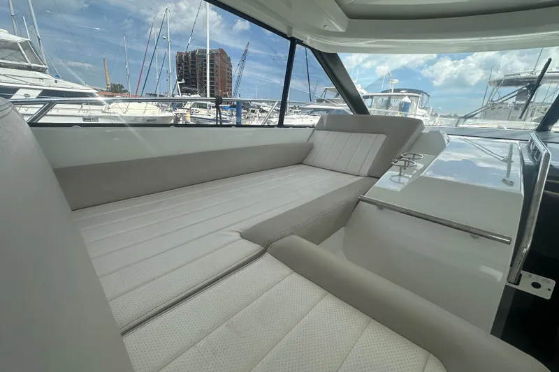 Slide: The Image of Interior view of 2015 Jeanneau Leader 40 yacht with comfortable seating and marina backdrop. - 28