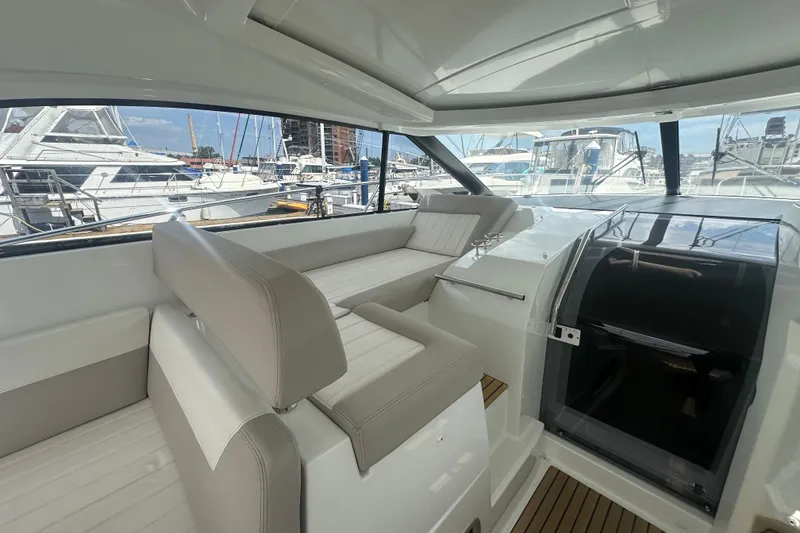 Slide: The Image of Interior view of 2015 Jeanneau Leader 40 yacht with seating and marina backdrop. - 19
