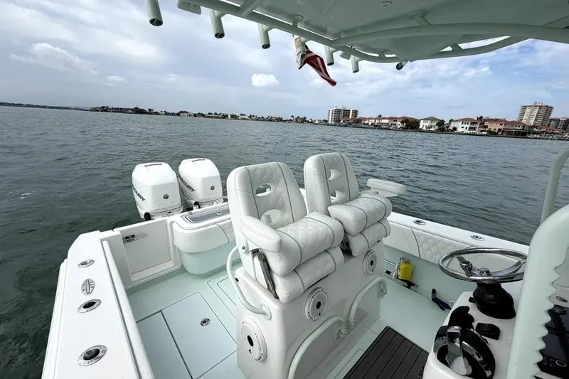 Slide: The Image of 2019 Contender 30 ST boat with dual engines on calm water, featuring luxurious seating. - 14