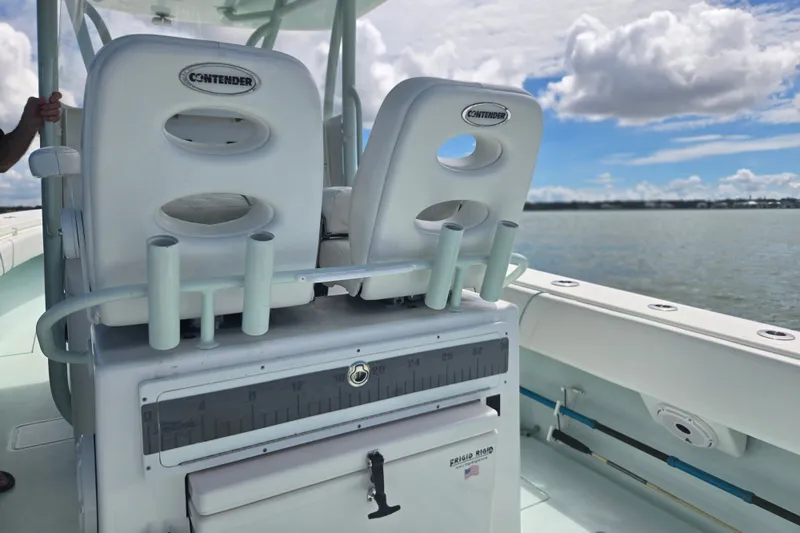 Slide: The Image of 2019 Contender 30 ST boat interior with rod holders and seating, overlooking calm waters. - 48