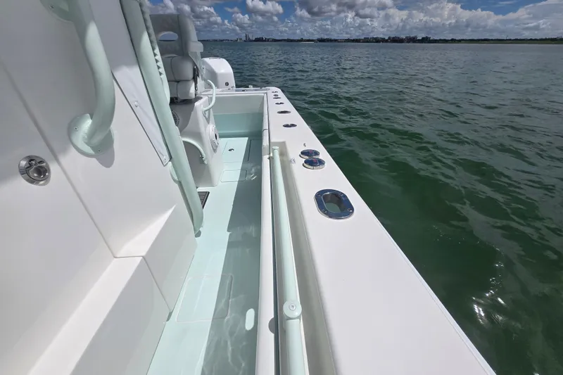 Slide: The Image of 2019 Contender 30 ST boat on calm water, showcasing sleek deck design and seating. - 33