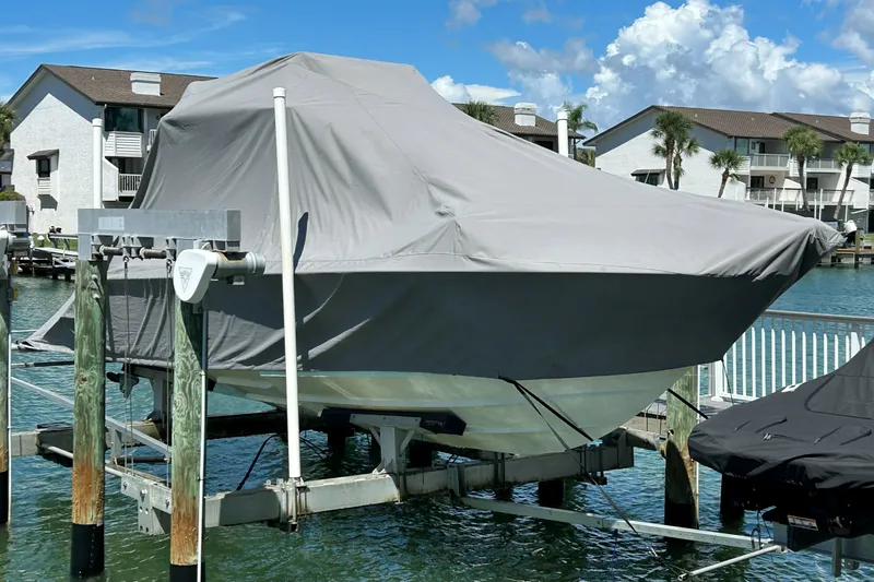 Slide: The Image of Covered 2019 Contender 30 ST boat on lift by waterfront homes. - 16