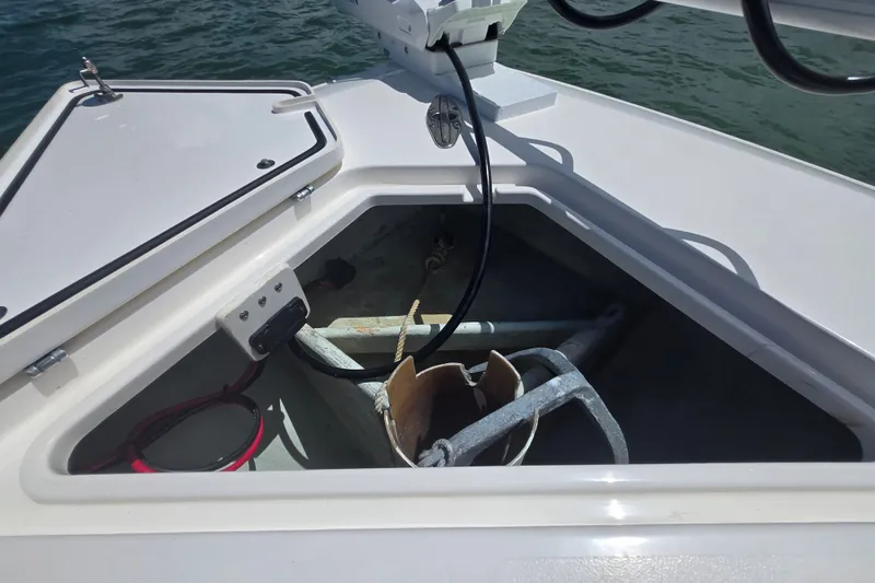 Slide: The Image of Anchor compartment of 2019 Contender 30 ST boat, open hatch, calm water background. - 64