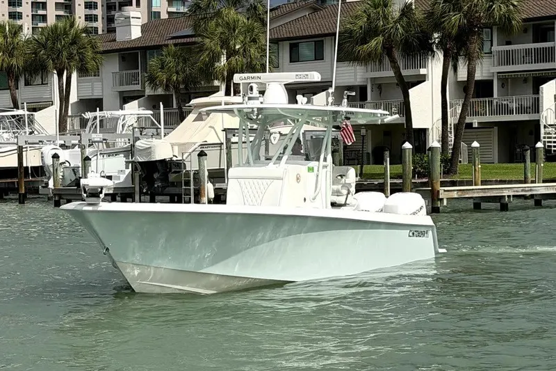 Slide: The Image of 2019 Contender 30 ST boat docked near waterfront homes with palm trees. - 1