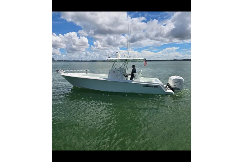 The Image of 2019 Contender 30 ST boat cruising on calm waters under a partly cloudy sky. - 0