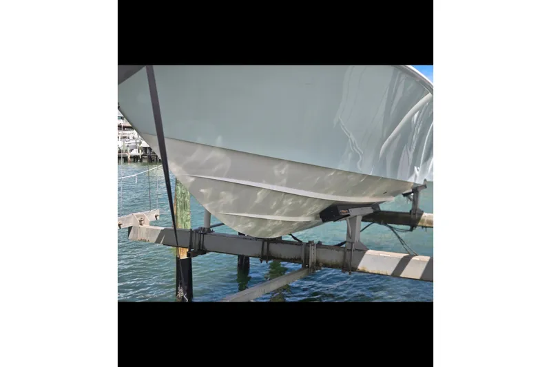Slide: The Image of 2019 Contender 30 ST boat hull on a lift over water. - 19